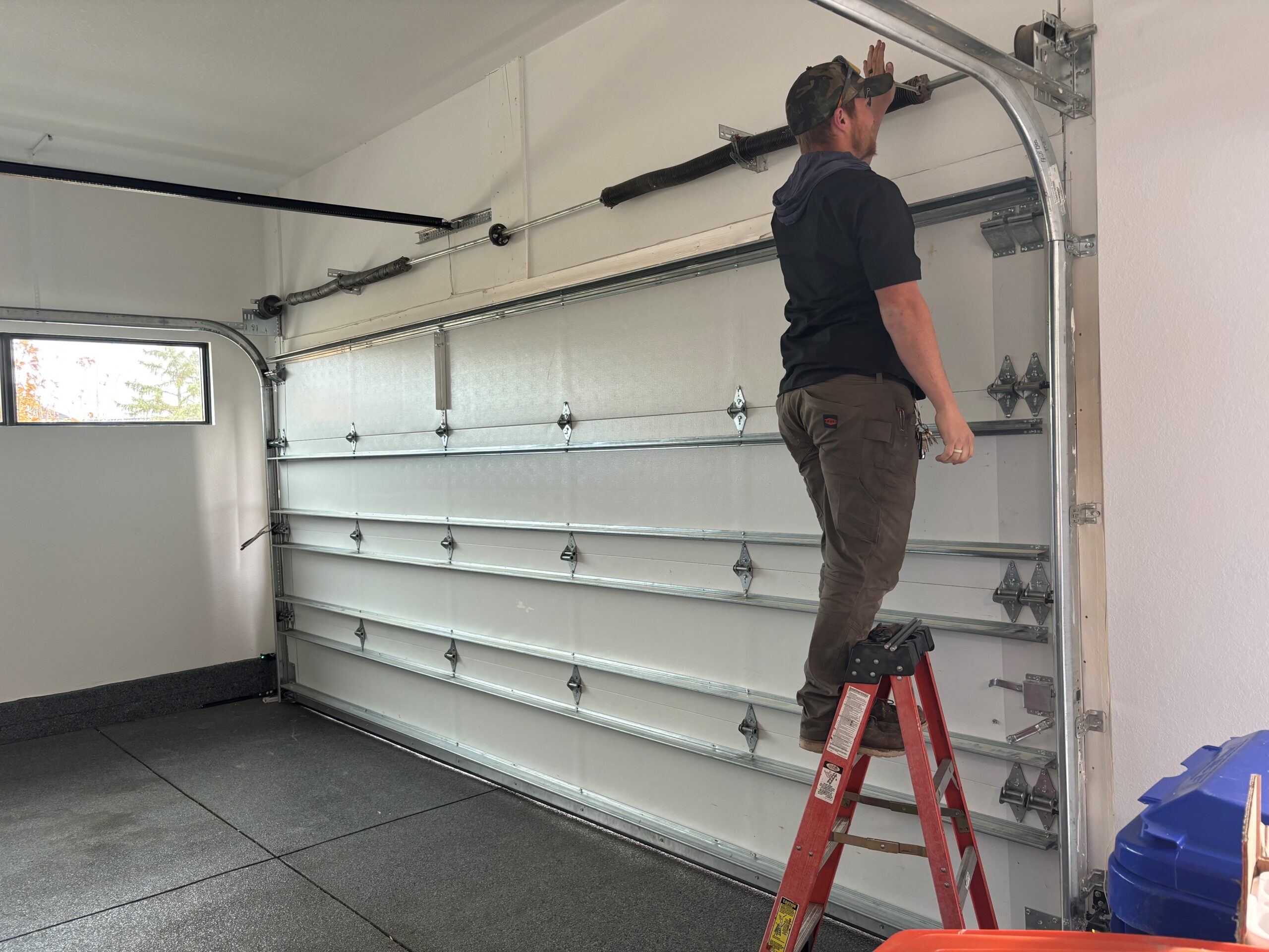 Experienced garage door technician repairing overhead door system